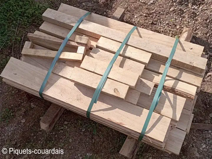 Photo des éléments en bois, planches, poigniées et barres, qui composent un kit de composteur en châtaignier